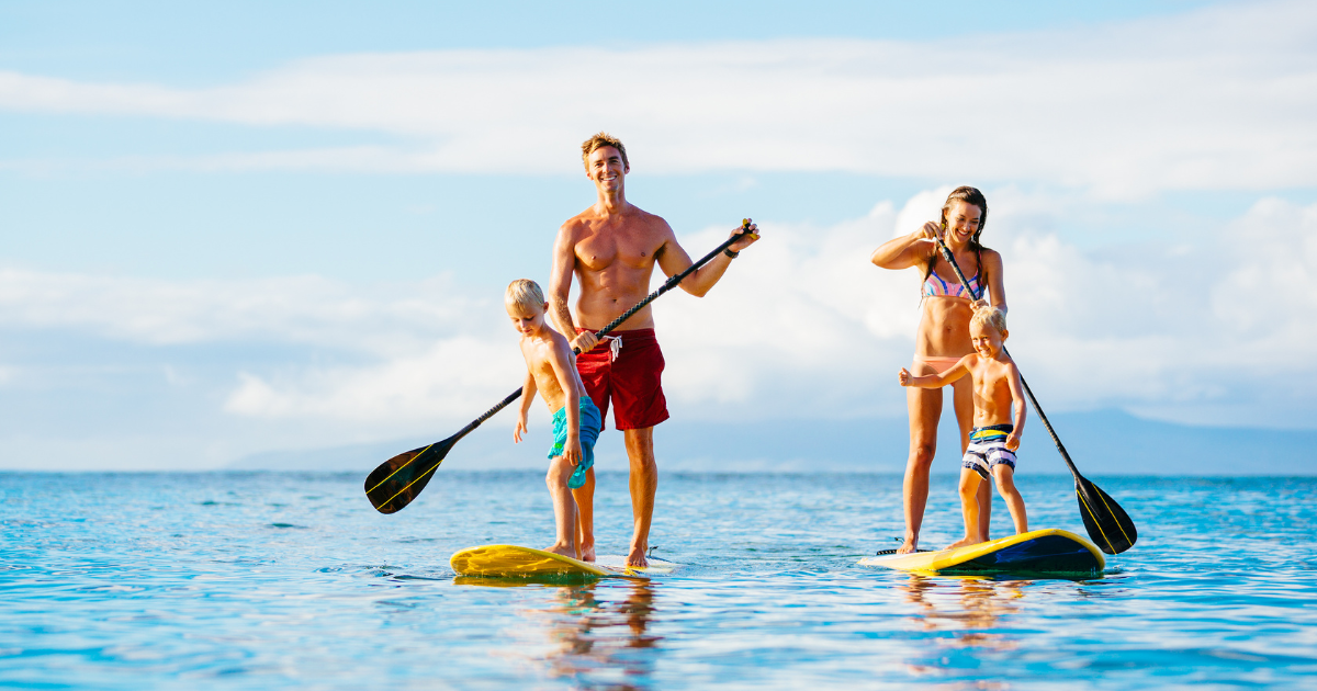 family of four paddle boarding
