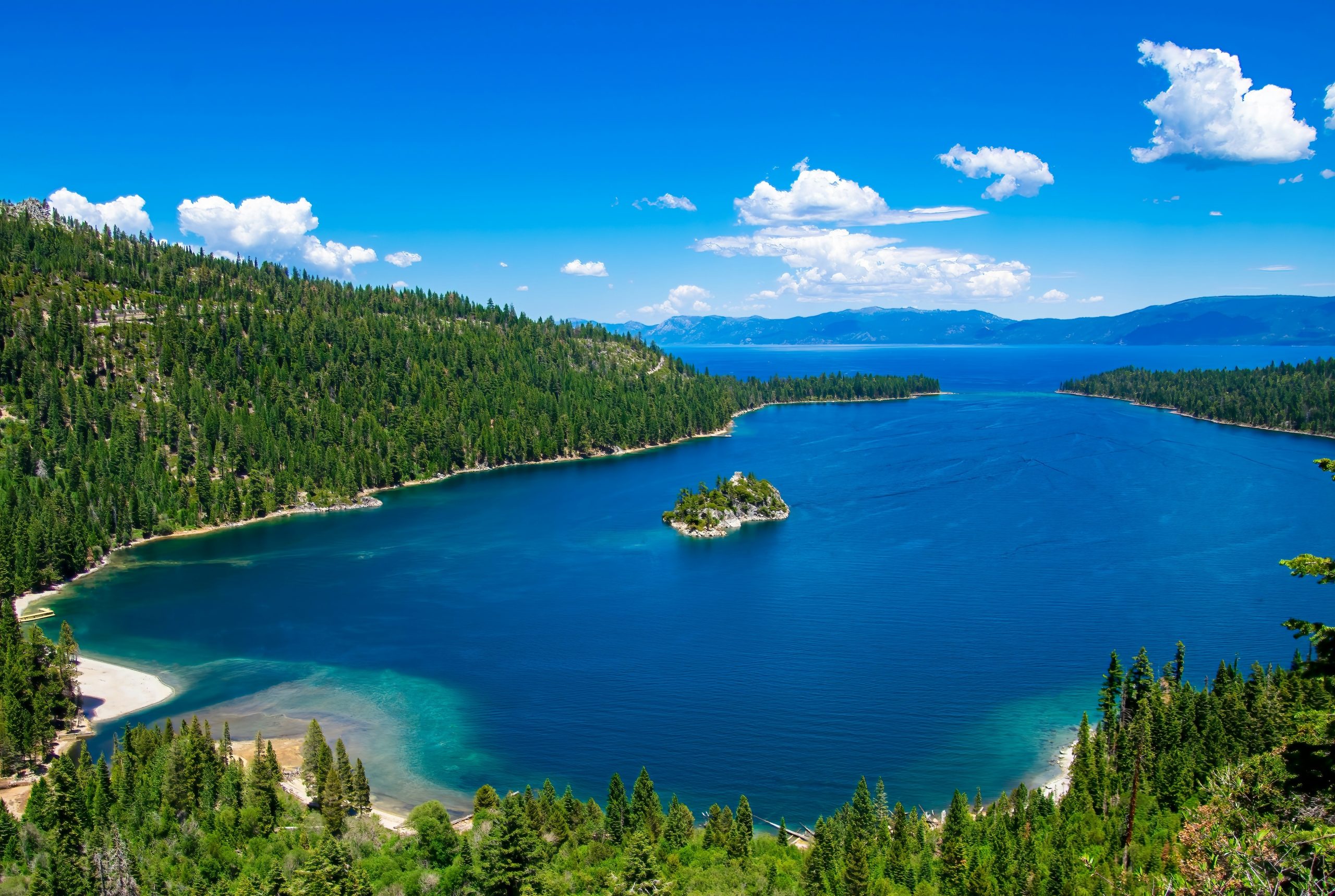 View above Emerald Bay State Park of blue water and tree-lined shores